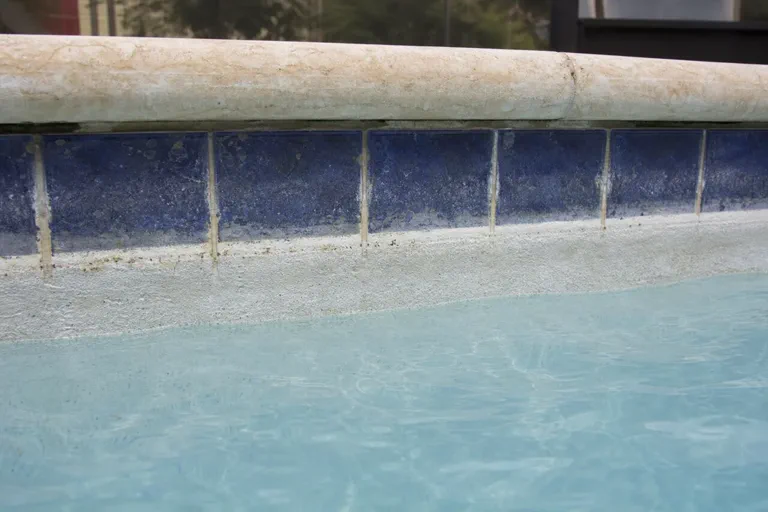 Close view of pool plaster wear near waterline